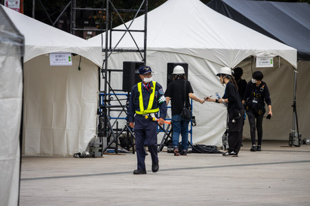 Tokyo, Japan, October 31, 2023: Security Guard Directing Crew at Event Setupのeditorial素材