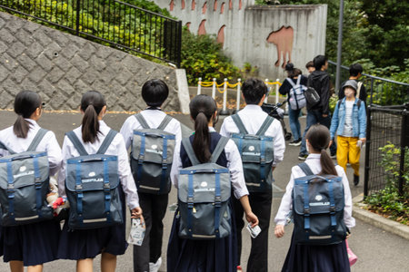 Tokyo, Japan, October 31, 2023: Group of school children with backpacks walking in lineのeditorial素材