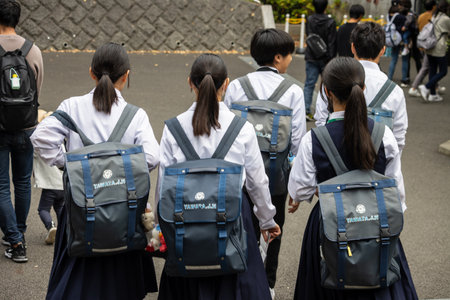 Tokyo, Japan, October 31, 2023: Group of Japanese students with backpacks walking togetherのeditorial素材