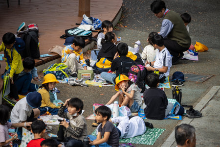 Tokyo, Japan, October 31, 2023: Children sitting and enjoying snacks during a school field tripのeditorial素材