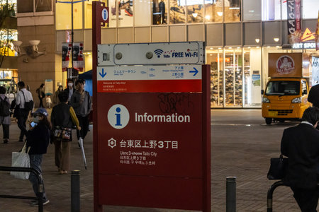 Tokyo, Japan, October 31, 2023: Information kiosk in a busy Tokyo shopping district with pedestrians