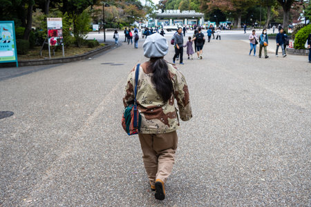 Tokyo, Japan, October 31, 2023: Woman walking down a busy path in Ueno Parkのeditorial素材