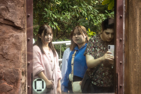 Tokyo, Japan, October 31, 2023: Young women taking a selfie in a mirror at an urban parkのeditorial素材