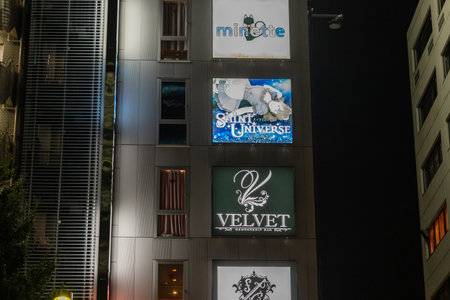 Tokyo, Japan, October 31, 2023: Facade of a building with multiple business signs illuminated at nightのeditorial素材