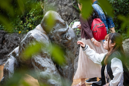 Tokyo, Japan, October 31, 2023: Visitor interacting with a gorilla statue in a zoo parkのeditorial素材