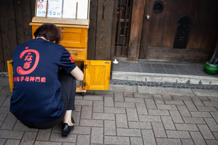 Tokyo, Japan, October 31, 2023: Employee taking a break outside a restaurantのeditorial素材