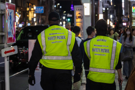Tokyo, Japan, October 31, 2023: Security personnel on night patrol in Tokyo's busy districtのeditorial素材