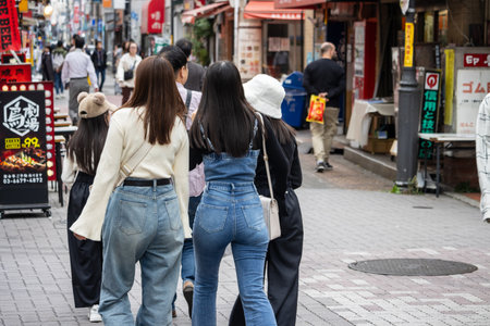 Tokyo, Japan, October 31, 2023: Young people walking together on a busy Tokyo streetのeditorial素材