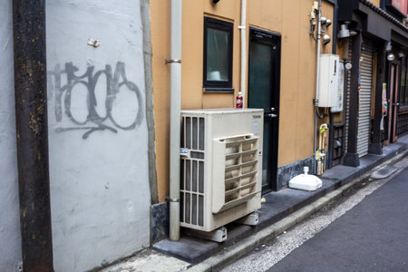Tokyo, Japan, November 1, 2023: Graffiti on a wall next to an air conditioning unit in a Tokyo alleyのeditorial素材