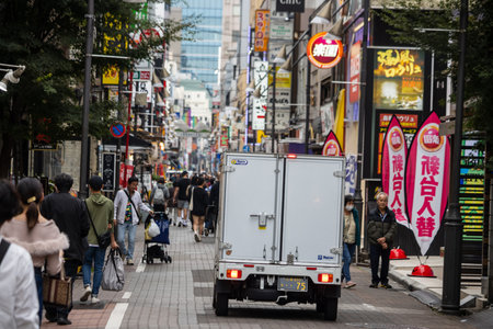 Tokyo, Japan, October 31, 2023: Busy shopping street with pedestrians and a delivery truckのeditorial素材