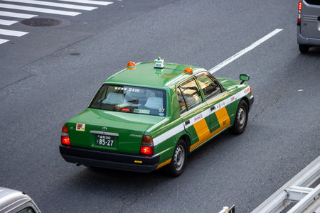 Tokyo, Japan, November 1, 2023: Green and yellow taxi on the streets of Tokyoのeditorial素材