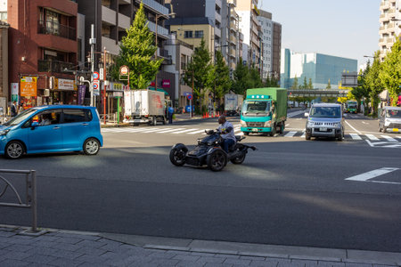 Tokyo, Japan, November 1, 2023: Motorcycle rider waiting at traffic lights on a busy Tokyo streetのeditorial素材