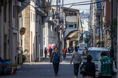 Tokyo, Japan, November 1, 2023: Quiet Tokyo neighborhood street with pedestrians and vehiclesのeditorial素材
