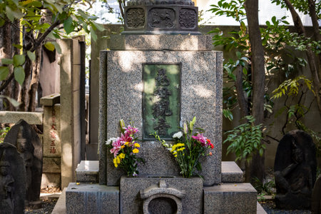 Tokyo, Japan, November 1, 2023: Traditional Japanese Grave with Fresh Flowers and Statuesのeditorial素材