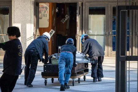 Tokyo, Japan, November 1, 2023: Workers Moving Equipment Outside a Building