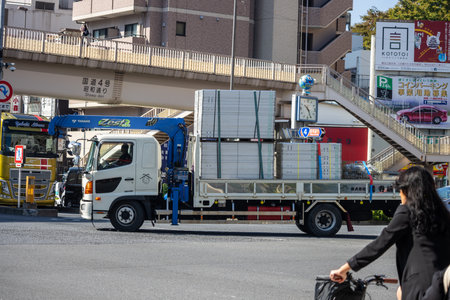 Tokyo, Japan, November 1, 2023: Utility Truck with Lifting Equipment on Urban Road