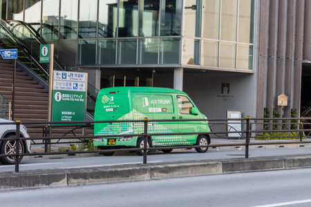 Tokyo, Japan, November 1, 2023: Green Delivery Van Parked on a City Streetのeditorial素材