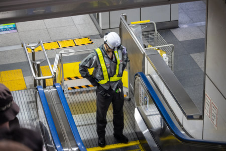 Tokyo, Japan, November 1, 2023: Maintenance Worker Inspecting Escalator in Subway Stationのeditorial素材