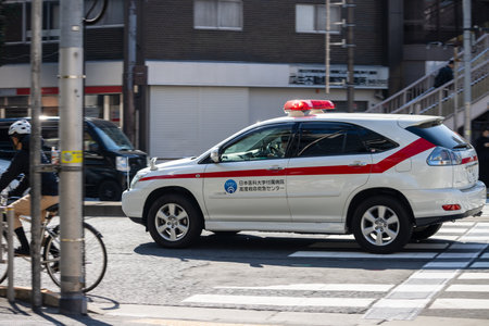 Tokyo, Japan, November 1, 2023: Emergency Vehicle and Cyclist on Tokyo Street