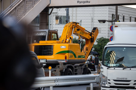 Tokyo, Japan, November 1, 2023: Construction Excavator on a Trailer in Trafficのeditorial素材