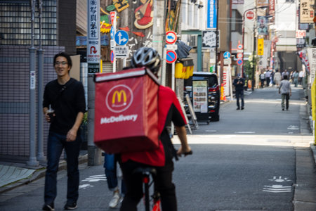Tokyo, Japan, November 1, 2023: McDonald's Delivery Service Biking Through Tokyo Streetsのeditorial素材