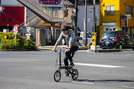 Tokyo, Japan, November 1, 2023: Man riding a foldable bike on the streets of Tokyoのeditorial素材