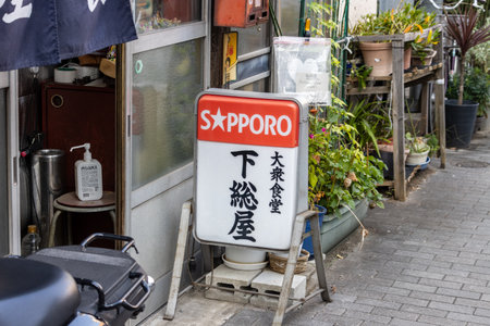 Tokyo, Japan, November 1, 2023: Sapporo beer sign outside a local Japanese tavernのeditorial素材