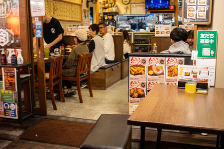 Tokyo, Japan, November 1, 2023: Customers dining in a cozy Japanese izakaya at nightのeditorial素材