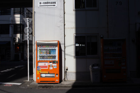 Tokyo, Japan, November 1, 2023: Bright Orange Vending Machine on a Quiet Streetのeditorial素材