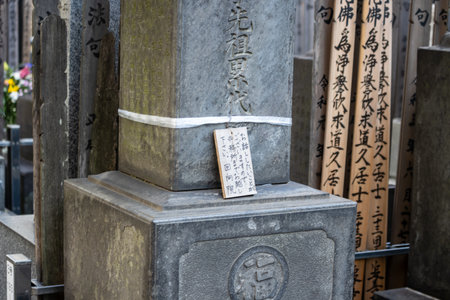 Tokyo, Japan, November 1, 2023: Traditional Japanese stone monument with inscriptions and a prayer slipのeditorial素材