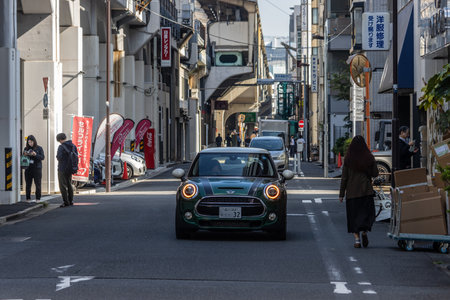 Tokyo, Japan, November 1, 2023: Classic Mini Cooper Driving Through Narrow Tokyo Alleyのeditorial素材