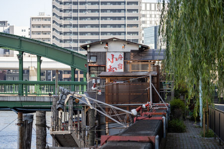 Tokyo, Japan, November 1, 2023: Quaint Restaurant by the Canal with a Bridge in the Backgroundのeditorial素材