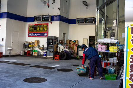 Tokyo, Japan, November 1, 2023: Worker Organizing Supplies in a Clean Auto Shopのeditorial素材