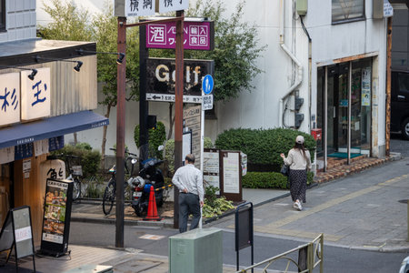 Tokyo, Japan, November 1, 2023: People Walking Past a Variety of Shops on a City Streetのeditorial素材
