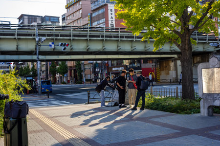 Tokyo, Japan, November 1, 2023: People Socializing in a City Plaza Under the Train Tracksのeditorial素材