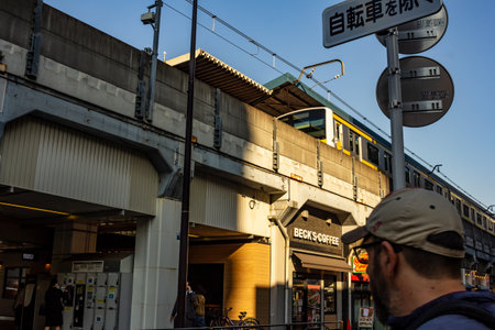 Tokyo, Japan, November 1, 2023: Commuters Near a Train Station with a Coffee Shopのeditorial素材