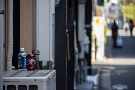 Tokyo, Japan, November 1, 2023: Dr. Pepper and Aquarius Drink Cans on a Window Ledge Overlooking a City Alleyのeditorial素材