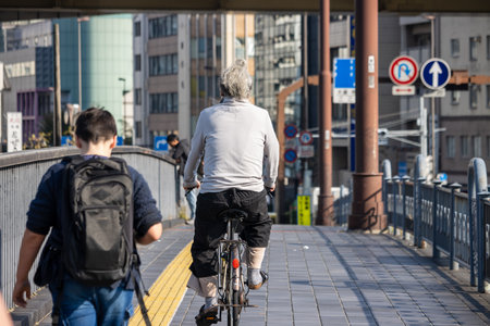 Tokyo, Japan, November 1, 2023: Cyclist and pedestrian sharing a path on a bridge in Tokyoのeditorial素材