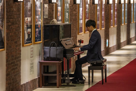 Tokyo, Japan, November 1, 2023: Young Man Playing Piano in a Subway Alleyのeditorial素材