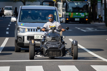 Tokyo, Japan, November 1, 2023: Man Riding a Three-Wheeled Motorcycle in the Cityのeditorial素材