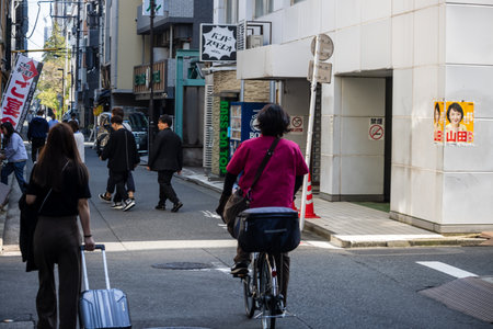 Tokyo, Japan, November 1, 2023: Pedestrians and cyclists on busy city street