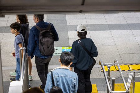 Tokyo, Japan, November 1, 2023: Commuters at a Tokyo Subway Station Waiting to Board the Trainのeditorial素材