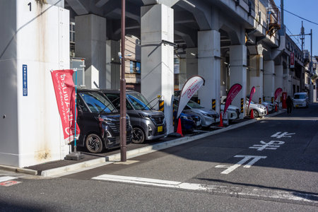 Tokyo, Japan, November 1, 2023: Row of parked cars under elevated highway near surfboard shopのeditorial素材