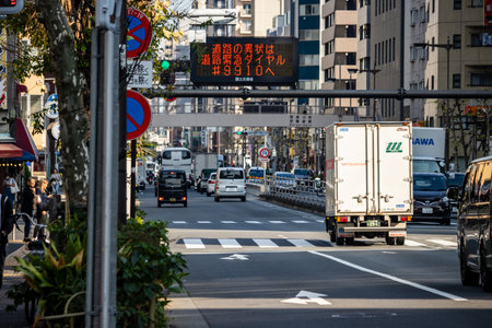Tokyo, Japan, November 1, 2023: Busy street scene with traffic and electronic display indicating traffic statusのeditorial素材