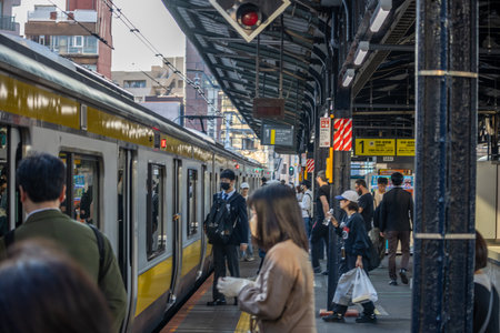 Tokyo, Japan, November 1, 2023: Commuters at a busy train station platformのeditorial素材