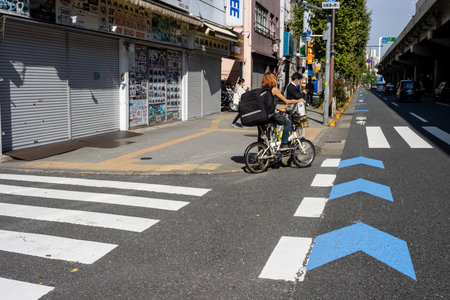 Tokyo, Japan, November 2, 2023: Cyclist and Pedestrians Crossing a City Streetのeditorial素材
