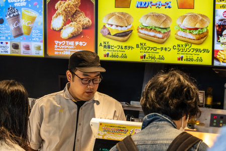Tokyo, Japan, November 2, 2023: Fast Food Restaurant Menu with Customer and Staff Interactionのeditorial素材