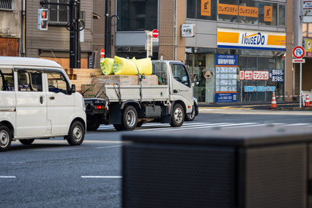 Tokyo, Japan, November 2, 2023: White Pickup Truck Carrying Construction Materials on City Streetのeditorial素材