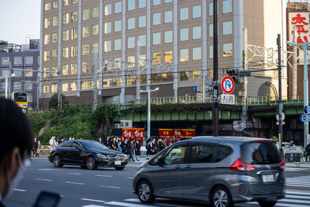 Tokyo, Japan, November 2, 2023: Urban street scene with train and pedestrian activity