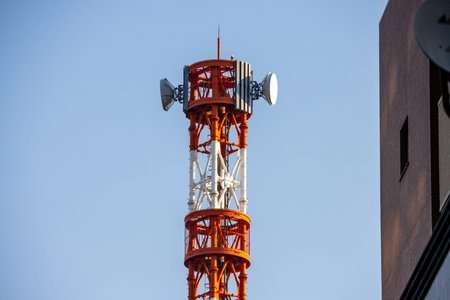 Tokyo, Japan, November 2, 2023: Red and White Communication Tower Against Blue Skyのeditorial素材